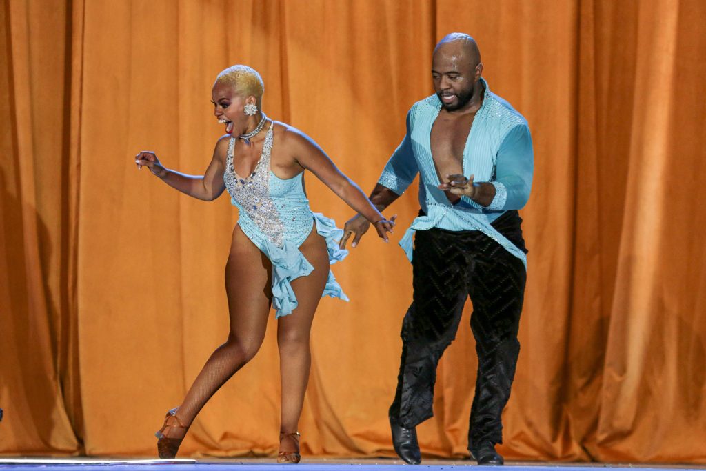 Pareja de bailarines de salsa caleña en competencia, realizando pasos rápidos y acrobáticos en el Coliseo El Pueblo durante el XX Festival Mundial de Salsa de Cali 2025.