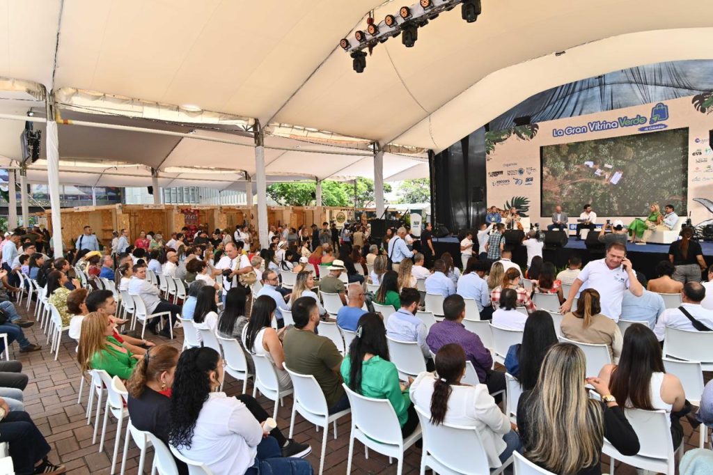 Gran Vitrina Verde de Colombia con más de 300 negocios sostenibles en Cali; se ve un evento cultural con zanqueros y stands de emprendimiento.