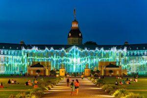 Ilustración colorida del skyline de Cali con iconos culturales como el Cristo Rey, iglesias y palmeras, representando las Media Arts como eje de desarrollo.
