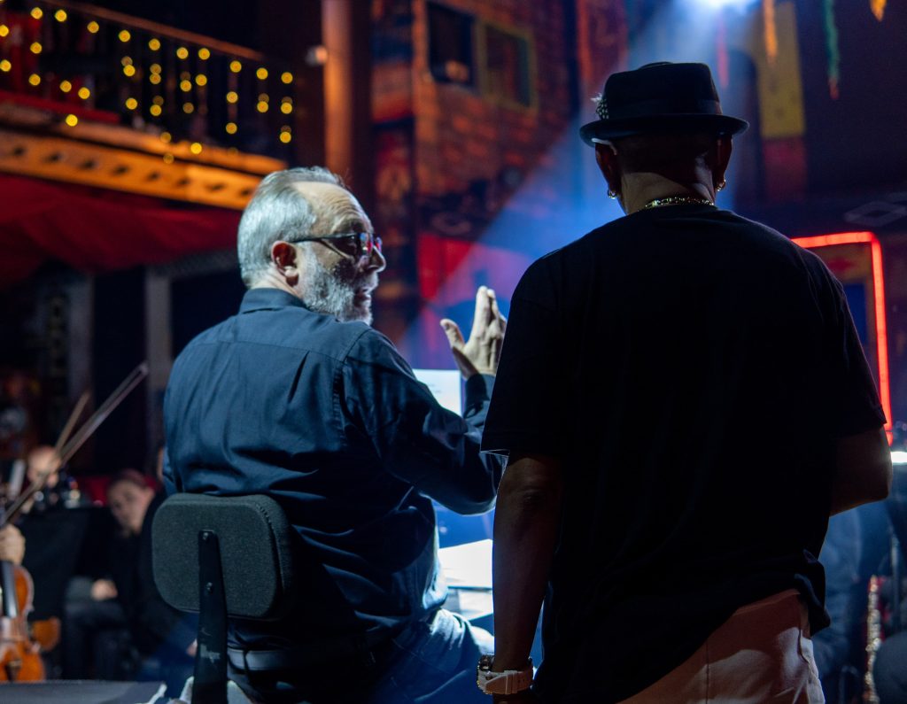 Concierto de la Orquesta Filarmónica de Cali y bailarines de Swing Latino en el Mulato Cabaret, con instrumentos sinfónicos y vestuarios de salsa vibrantes.