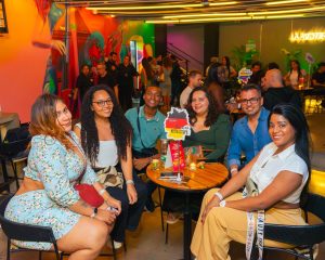 Multitud de personas interactuando y practicando idiomas en un evento nocturno con música en el rooftop La Azotea de Cali.