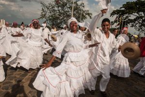 Músicos y danzantes afrocolombianos celebrando con marimbas y tambores en el Desfile de Apertura del Carnaval del Fuego en Tumaco.